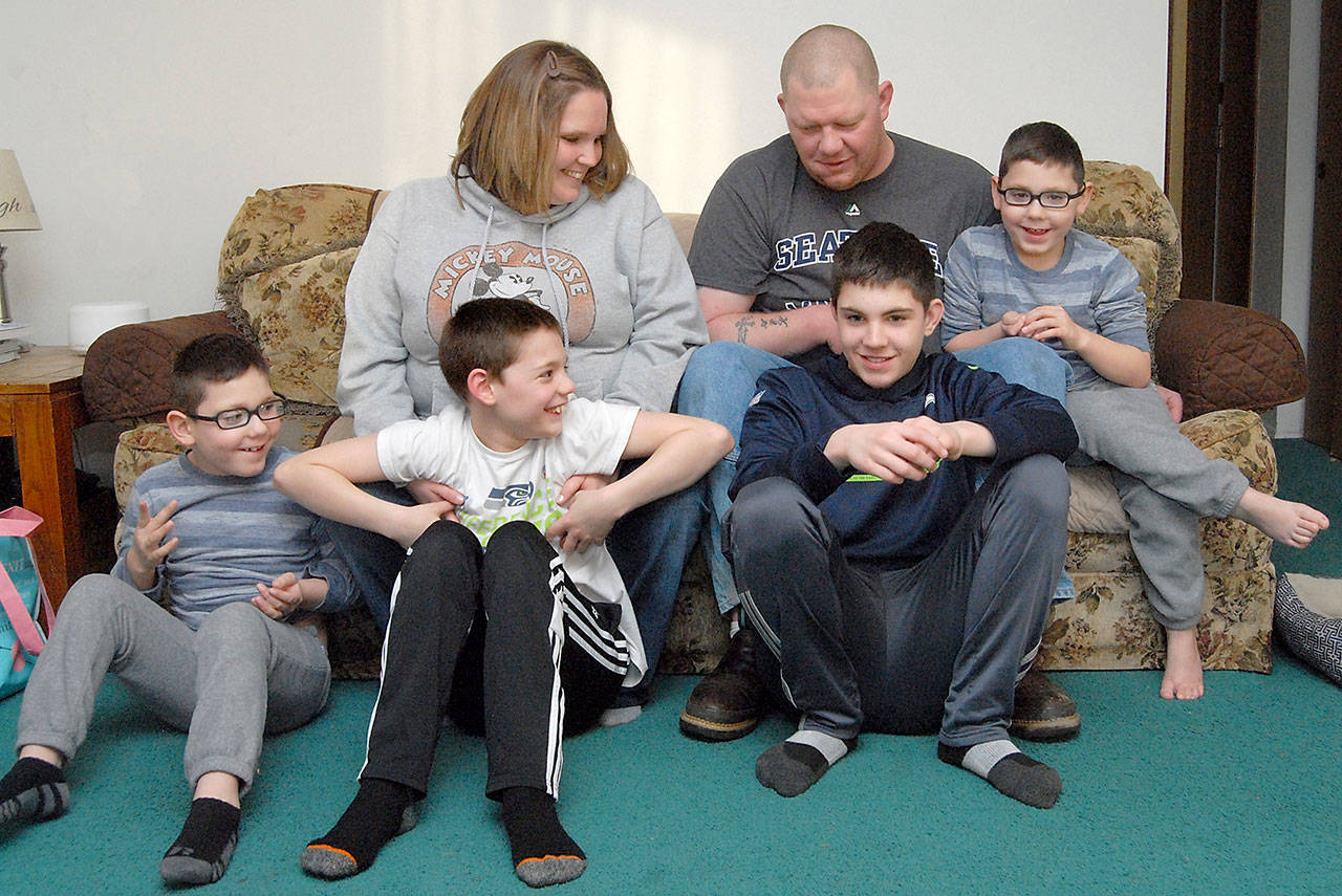 Shelby Knudson Bell, top left, is shown with her family, Nick Bell, top right, and children, from left, Deacon, 7, Nicholas, 10, Zaine, 12, and Camron, 7, in their Port Angeles home. Shelby Bell was recently selected to receive a Parent Recognition Award as part of the Children’s Trust of Washington Unsung Hero Award. (Keith Thorpe/Peninsula Daily News)
