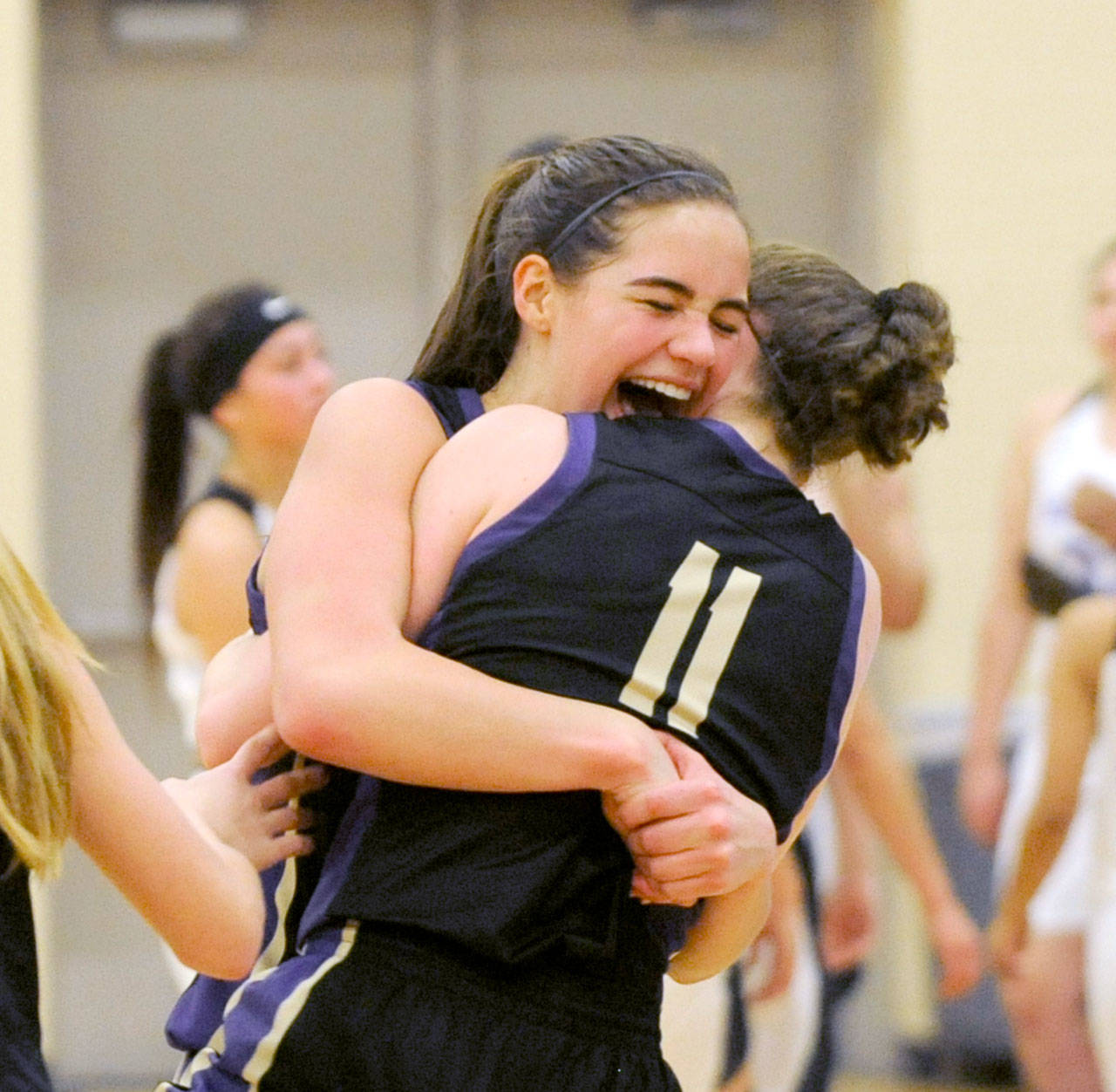 Michael Dashiell/Olympic Peninsula News Group Sequim’s Hope Glasser, left, and Abby Schroeder celebrate the Wolves’ come-from-behind 54-44 victory over Foster to advance to the Class 2A State Tournament.