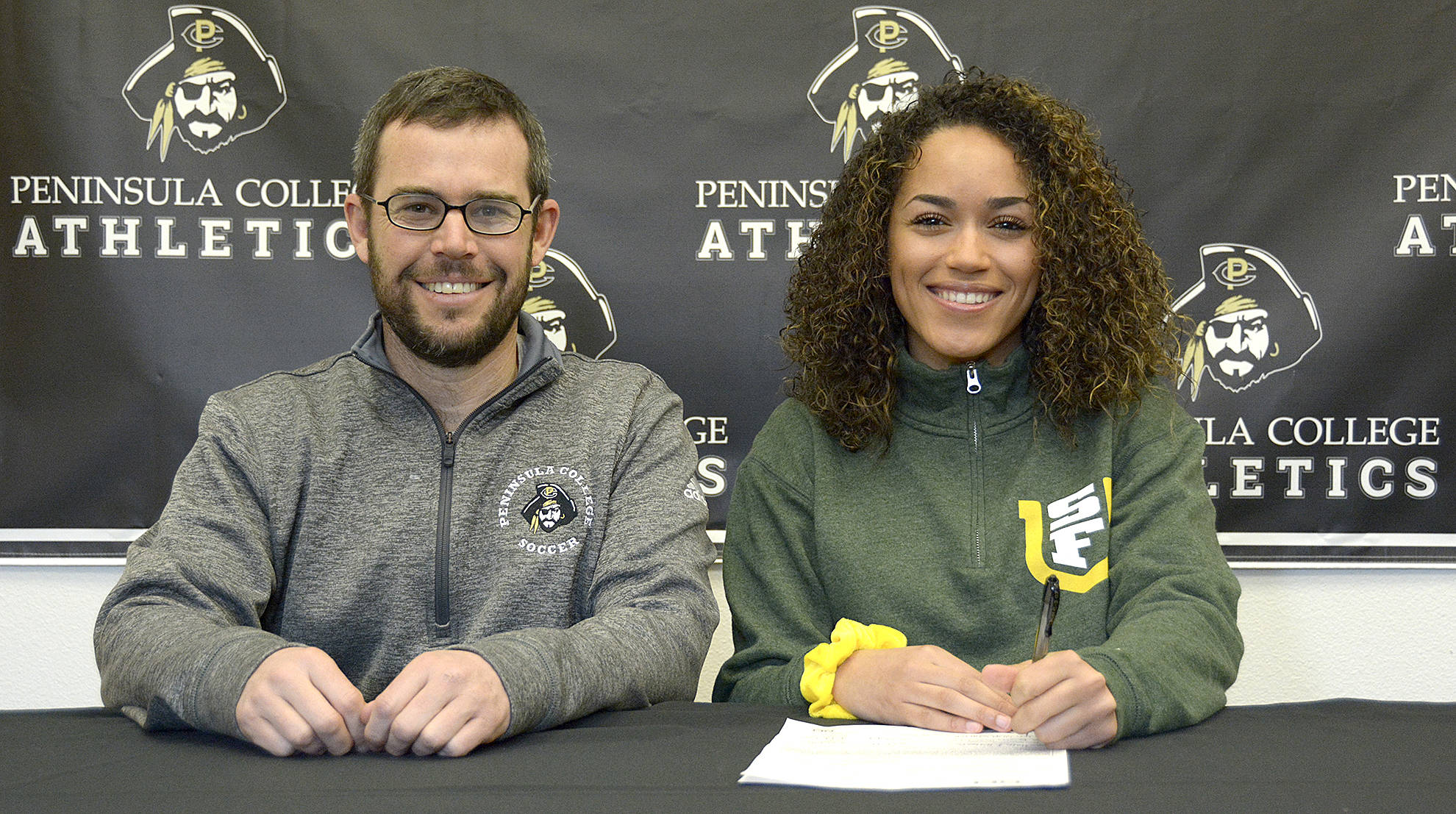 Peninsula College women’s soccer head coach Kanyon Anderson and player Halle Watson at Watson’s signing ceremony last week. The Peninsula College defensive back will play next year for the University of San Francisco.