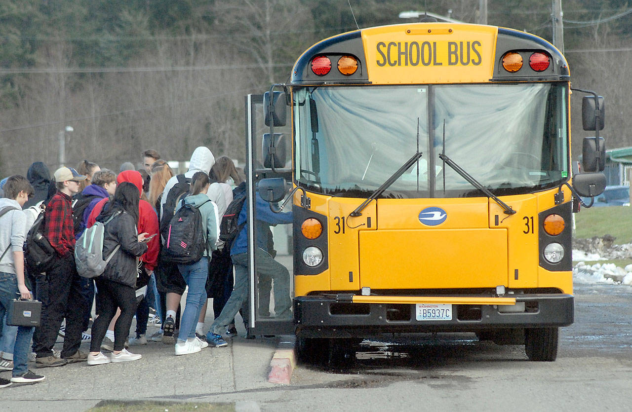 With patches of snow still covering parts of the campus, students board a bus at Port Angeles High School. (Keith Thorpe/Peninsula Daily News)                                With patches of snow still covering parts of the campus, students board a bus at Port Angeles High School. (Keith Thorpe/Peninsula Daily News)