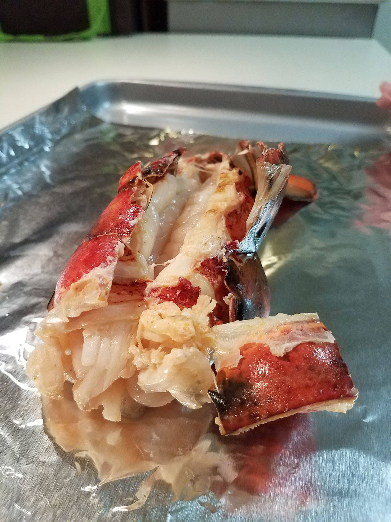 Now done, a grilled lobster tail awaits its fate. (Emily Hanson/Peninsula Daily News)