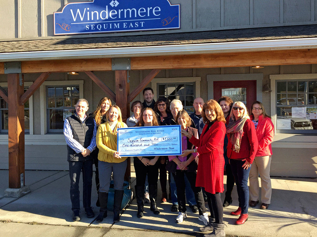 Kathy Suta of Sequim Community Aid accepts a $1,000 donation from Windermere Real Estate brokers in Sequim. Pictured, from left, are Alan Burwell, Kylie Walters, Marcee Medgin, Carol Dana, Jessica Warriner, Andrew Bradshaw, Dianna DaSilva, Dave Sharman, Cathy Reed, Joel Miller, Kathy Suta, Dollie Sparks, Jody McLean and Sheryl Payseno Burley.