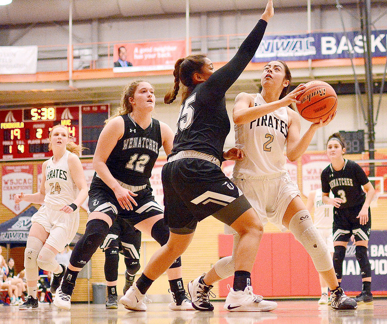 Jay Cline Peninsulas Leilani Padilla looks to shoot against Wenatchee Valleys Cariann Kunkel (12) and Ashley Peralta (25). At left is Peninsulas Kameron Bowen.