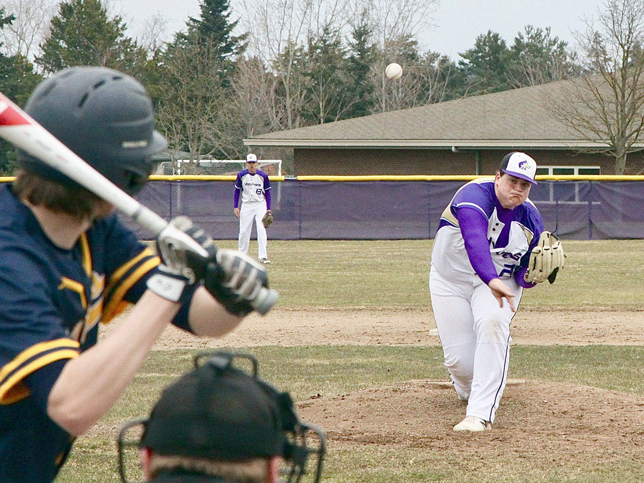 Sequims starting pitcher Caleb Pozernick fires a pitch to a Forks batter as the first game for both teams was played Monday at the Sequim field on a cold day with temperatures just 10 degrees above freezing.