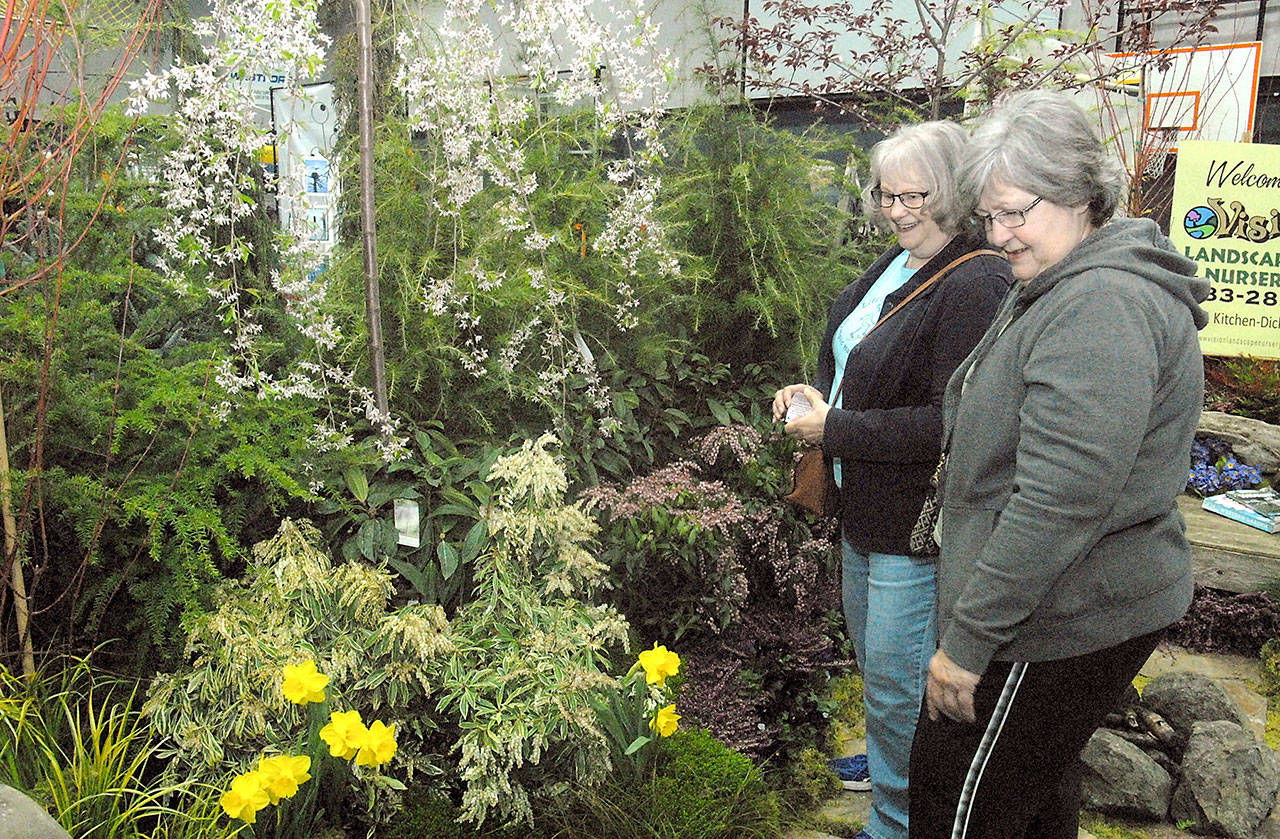 Beverly LaFay, left, and her sister, Judy Mosset, both of Sequim, look over a display of garden plants at a vendor booth set up by Sequim-based Vision Landscape Nursery during last year’s 20th annual Soroptimist Gala Garden Show at the Sequim unit of the Boys & Girls Clubs of the Olympic Peninsula. (Keith Thorpe/Peninsula Daily News)