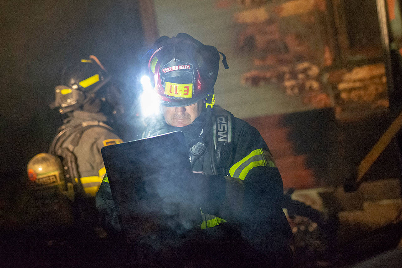 Port Angeles Fire Department Capt. Jamie Mason at the scene of a house fire in Port Angeles Wednesday night. (Jesse Major/Peninsula Daily News)