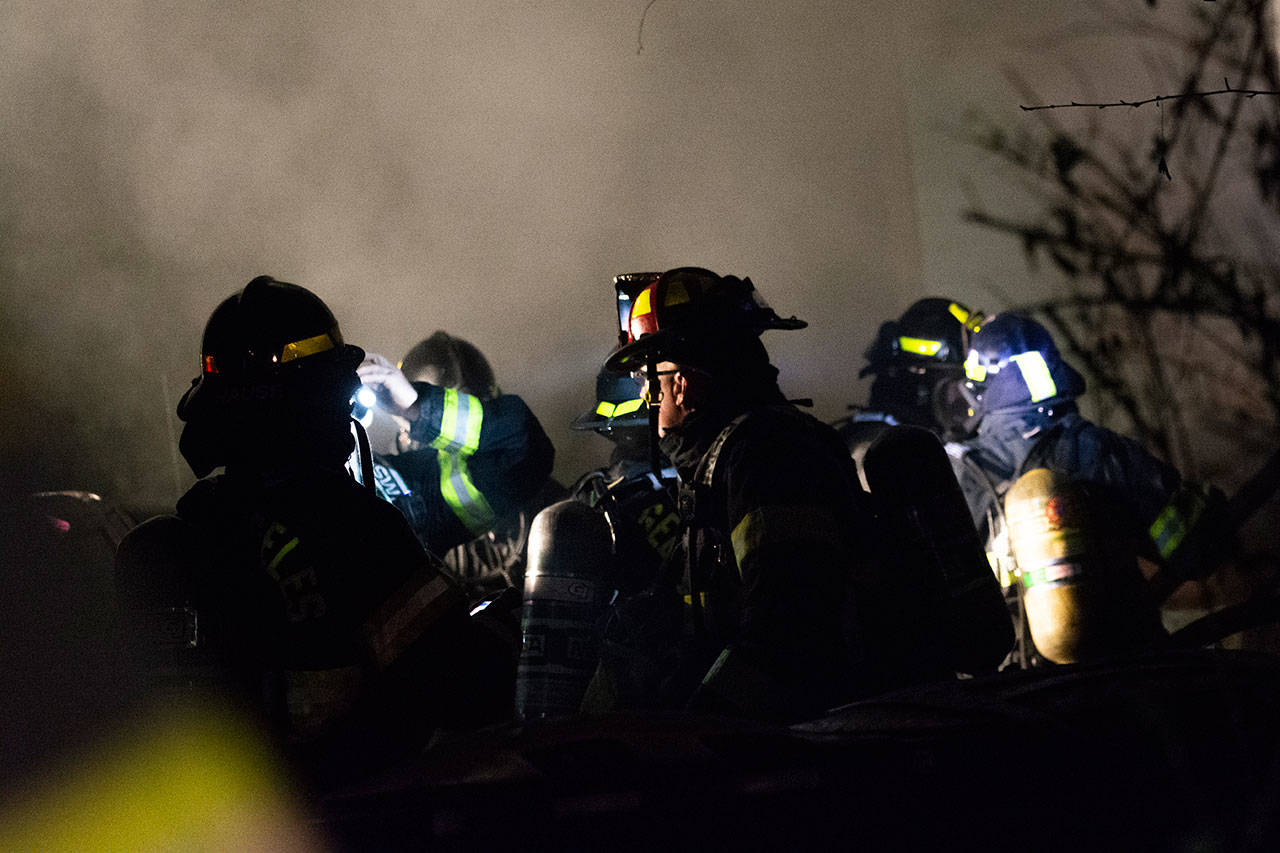 Firefighters on scene at a house fire in Port Angeles on Wednesday night. (Jesse Major/Peninsula Daily News)