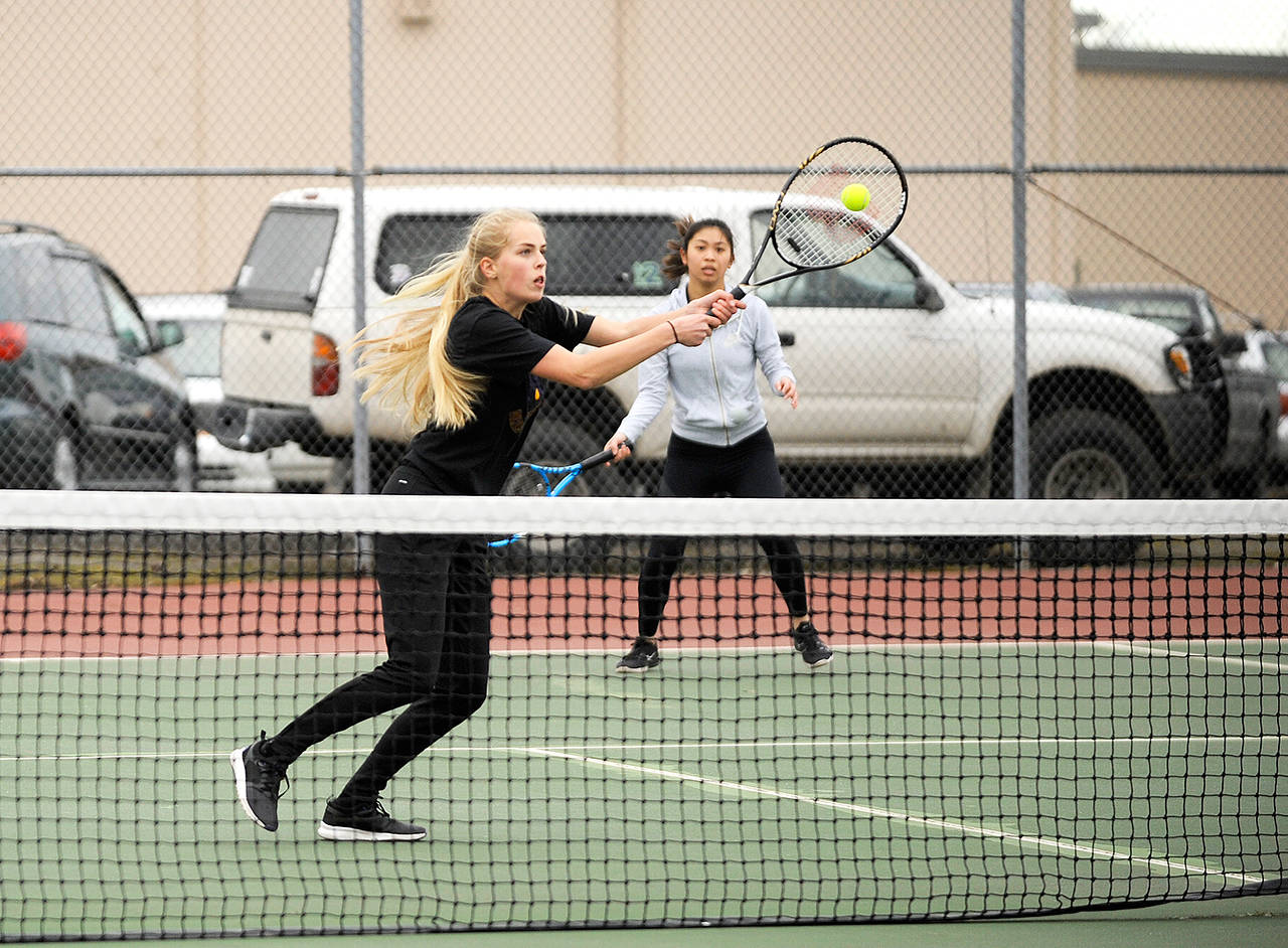 Michael Dashiell/Olympic Peninsula News Group Sequim’s Eden Johnson, front, returns a shot while doubles partner Amanda He watches during a match against Port Angeles’ Dency Patal and Elle Getchell.