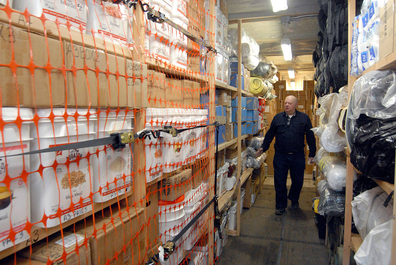Earthquake preparedness advocate Jim Buck walks through a shipping container filled with food and community supplies at an undisclosed location near Joyce. (Keith Thorpe/Peninsula Daily News)