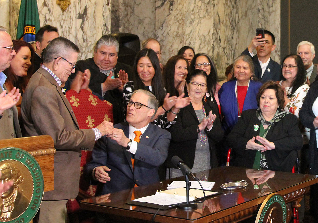 Gov. Jay Inlsee signs into law the Native American Voting Rights Act which allows the use of non-traditional addresses to be used for voter registration for residents who live on Native American reservations. (Emma Epperly/WNPA Olympia News Bureau)
