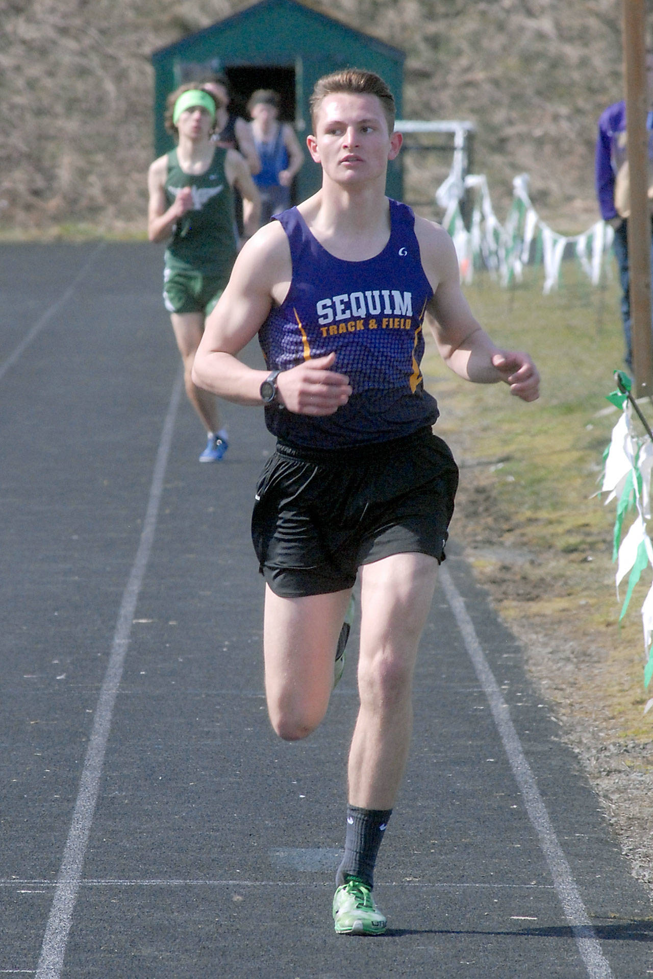 Keith Thorpe/Peninsula Daily News Sequim’s Murray Bingham crosses the finish line to take first in the boys 1,500-yard race as Port Angeles’ Thomas Shaw follows to take second at Saturday’s Port Angeles Invitational meet at Port Angeles High School.