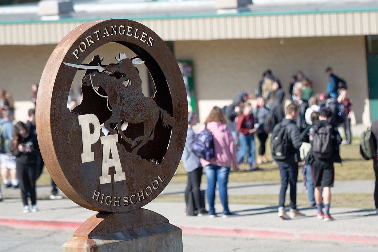 Students at Port Angeles High School wait for buses after school. The Port Angeles School District has sent notices to 18 staff members. (Jesse Major/Peninsula Daily News)