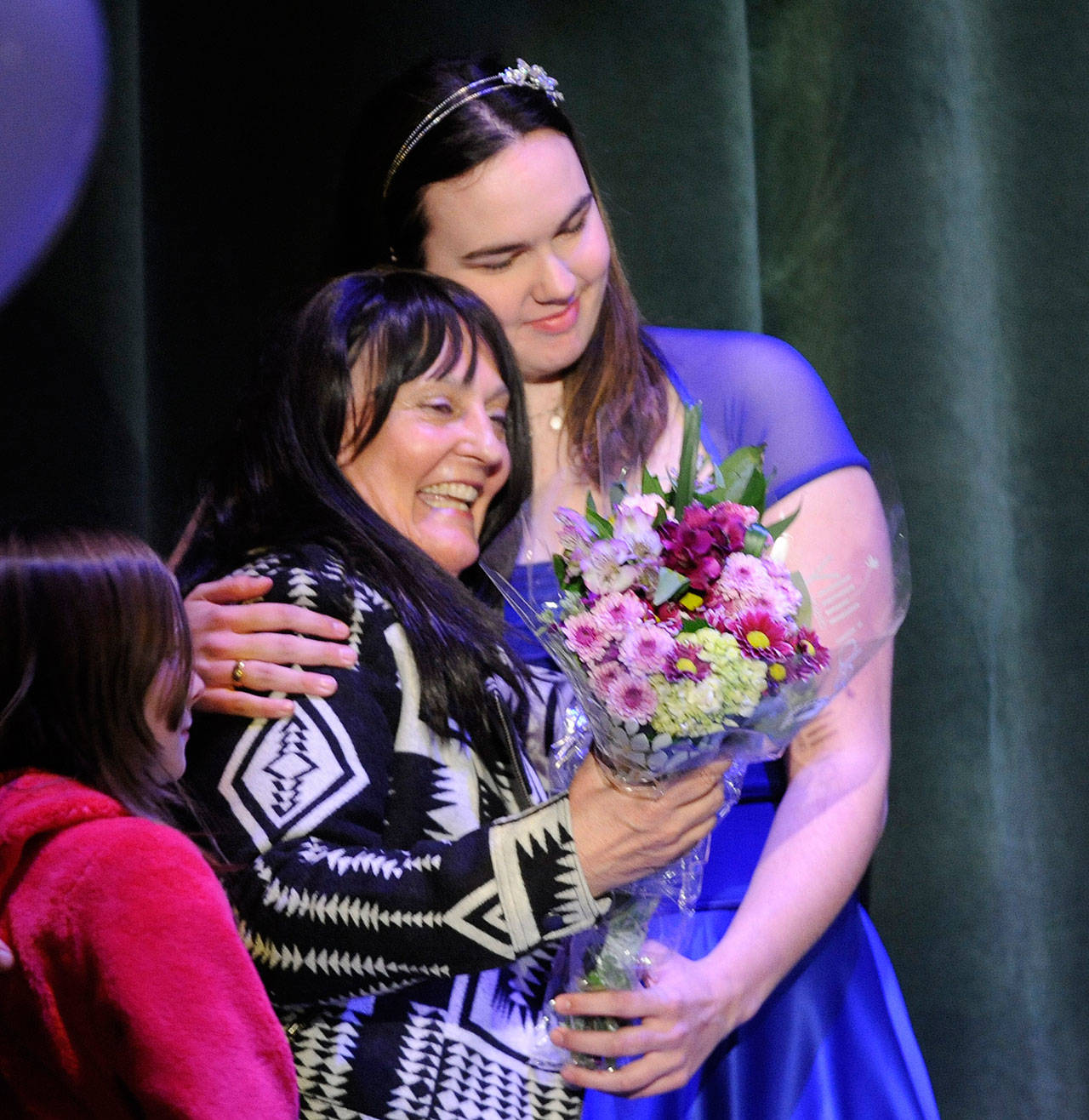 Linda Barnett, left, gets a hug from talent show co-host Allison Locke at the March 8 “I Cross My Heart” fundraiser. (Michael Dashiell/Olympic Peninsula News Group)