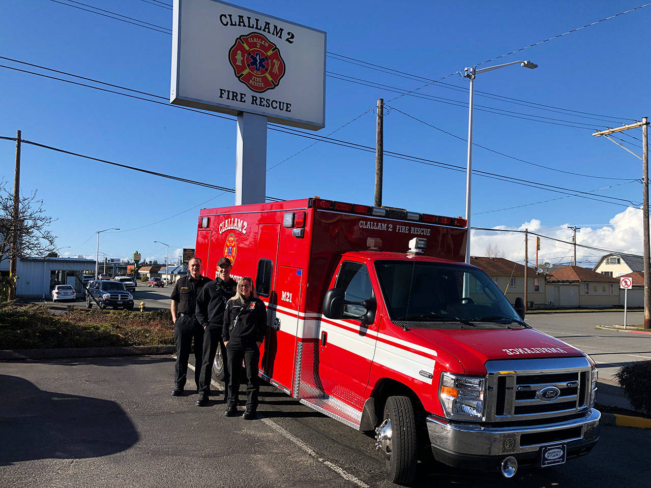 Deputy Fire Chief Jake Patterson, left, Firefighter-EMT Tyler Gear and Firefighter-Paramedic Margie Brueckner are shown with the latest addition to the Clallam County Fire District No. 2 fleet of ambulances. (Clallam County Fire District No. 2)