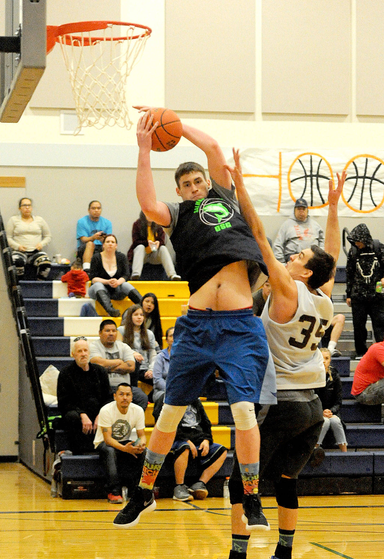 Lonnie Archibald/for Peninsula Daily News Marky Adams, who has played for Forks High School and Peninsula College and currently plays for St. Martin’s University, grabs a rebound for Olympic Sporting Goods of Forks over Black Diamond Electric’s Cal Shell in the championship game of the Nate Crippen Memorial Tournament held in Forks over the weekend. OSG defeated Black Diamond Electric 69-61.