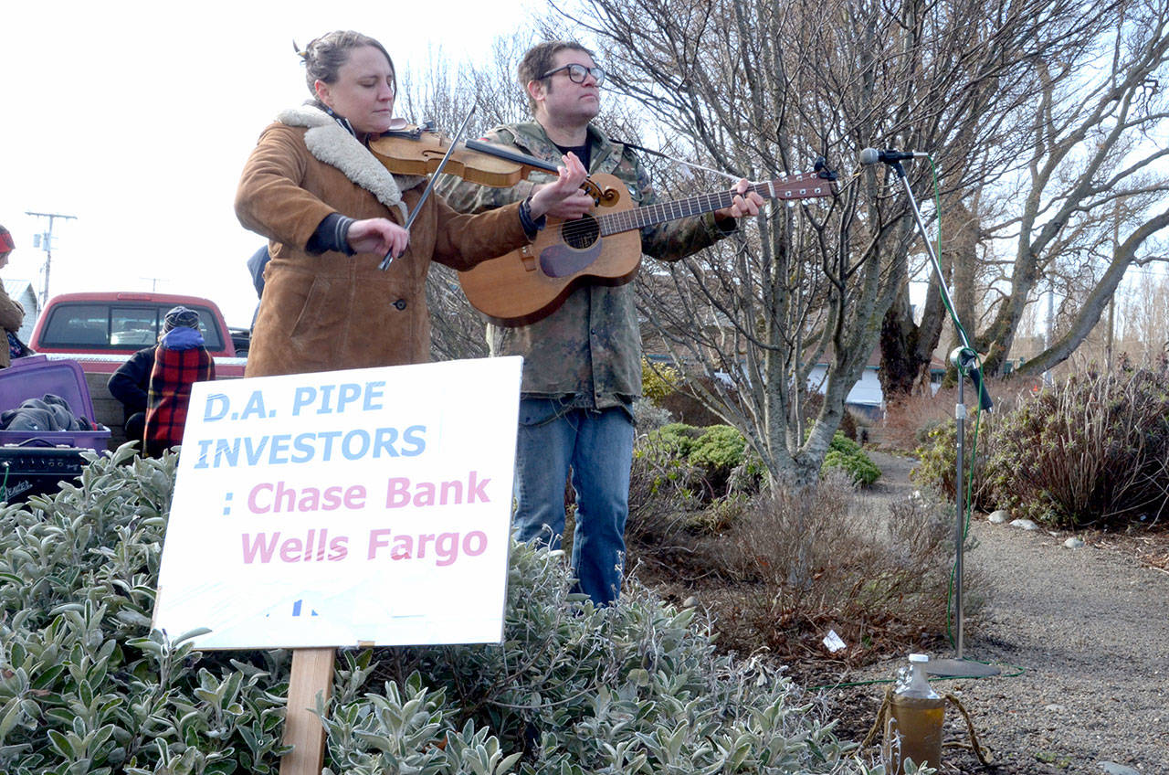 Emily Madden and Jarrod Bramson of the band Solvents play music at a protest against the Dakota Access Pipeline in Port Townsend in this 2017 file photo. (Peninsula Daily News)
