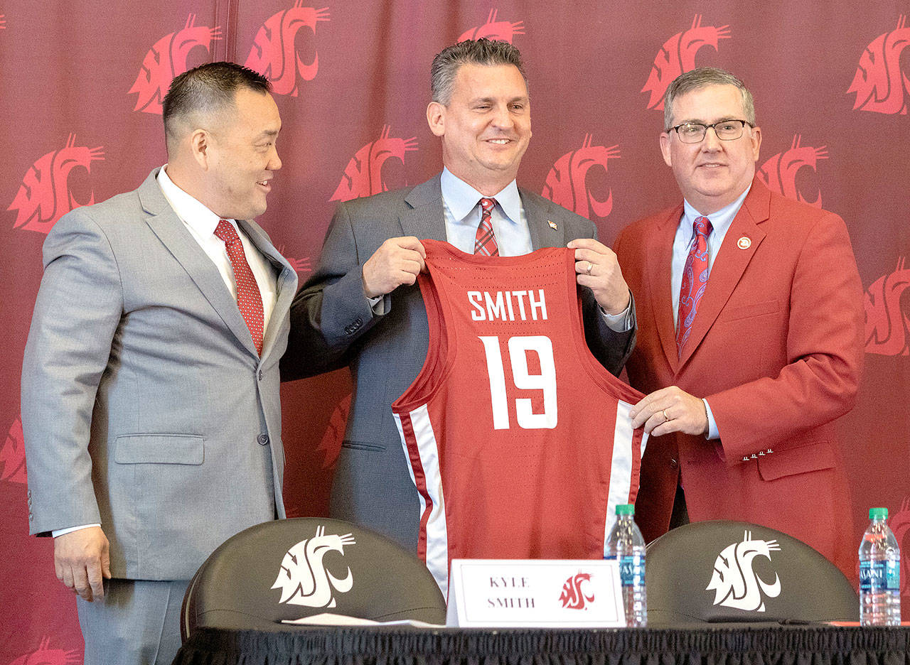Washington State new head men’s basketball coach Kyle Smith, center, poses with athletic director Patrick Chun, left, and school President Kirk Schulz during a news conference on Monday, April 1, 2019, in Pullman, Wash. (Geoff Crimmins/Moscow-Pullman Daily News via AP)