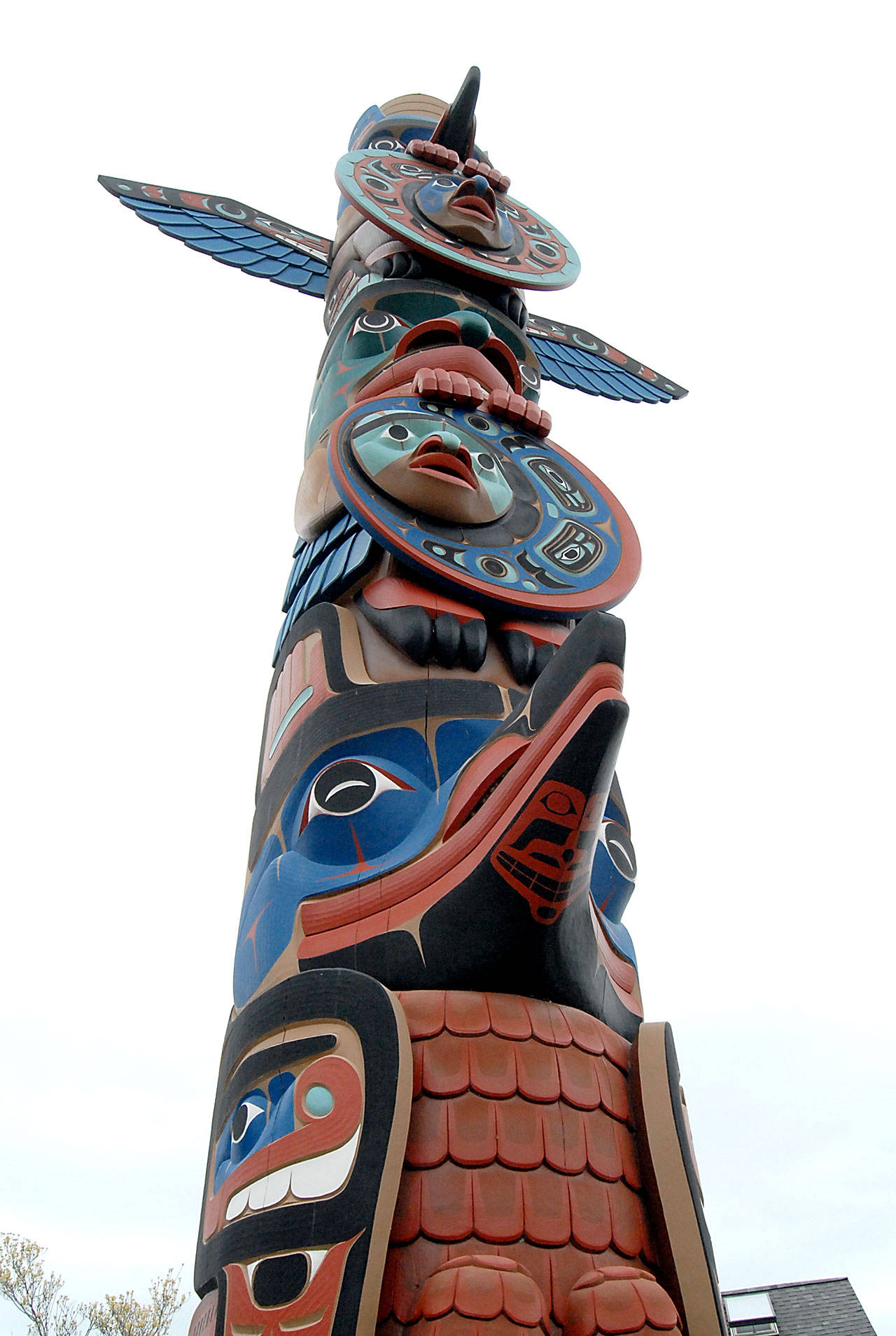 A totem pole named “Why the Sun Always Shines in Sequim” towers over the Sequim Civic Center. (Keith Thorpe/Peninsula Daily News)