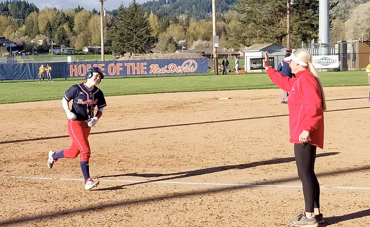 Submitted photo Port Angeles’ Lauren Lunt prepares to high five Lower Columbia head coach Traci Fuller after Lunt homered for the Red Devils in a win over rival Centralia on Friday.