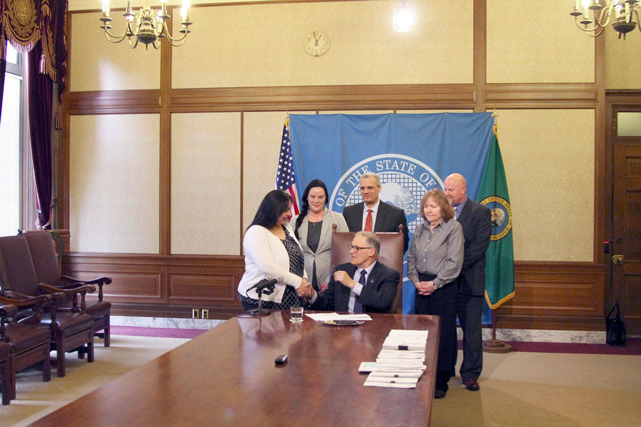 Gov. Jay Inslee signs Sen. Manka Dhingra’s bill earlier this month. The bill requires information to be provided to felons on their voting rights after being released from custody. (Emma Epperly, WNPA Olympia News Bureau)