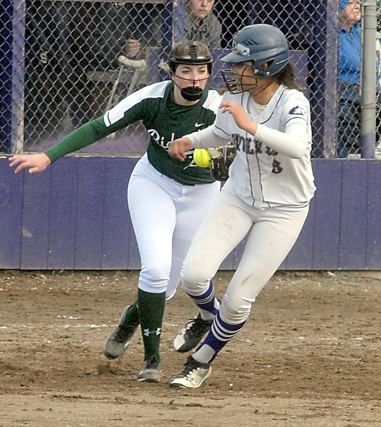 Keith Thorpe/Peninsula Daily News Sequim’s Kiana Robideau, right, gets caught off the bag and is chased down by Port Angeles first baseman Aeverie Politika in the first inning on Friday at Sequim High School.
