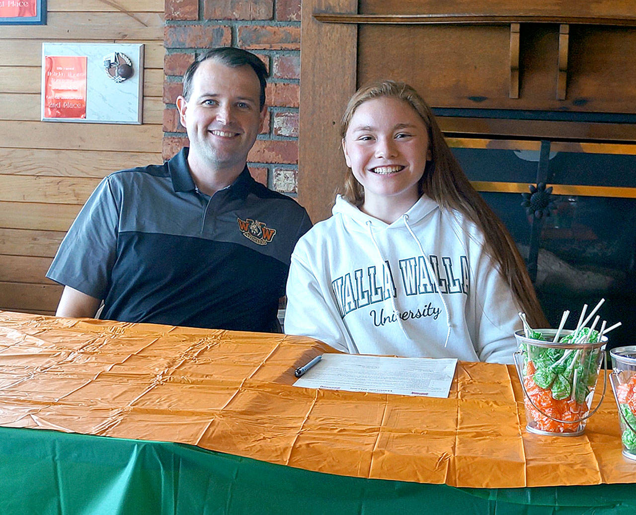 Clallam Bay High School’s Hannah Olson, right, signed on Friday to play basketball for Walla Walla University at the Breakwater Restaurant. With her is her college coach Paul Starkebaum. Olson, a Neah Bay resident and a member of the Makah Tribe, played basketball and volleyball for Clallam Bay and is wrapping up her final track season at the school.
