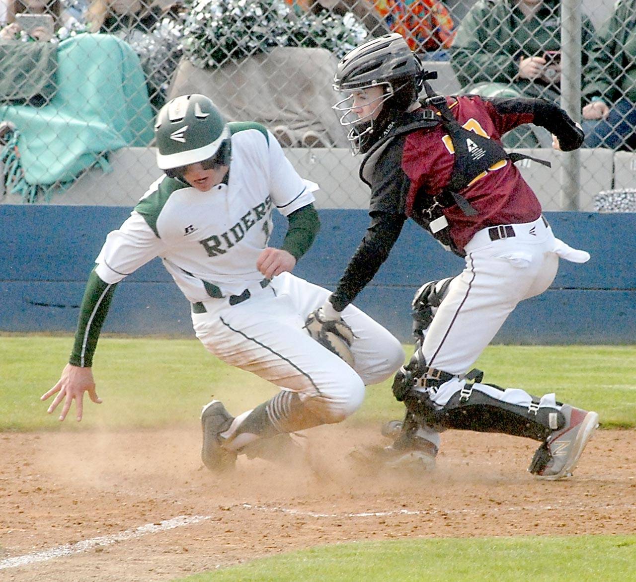 Port Angeles’ Ethan Flodstrom, left, attempts to steal home as Kingston catcher Tyler Bates cuts him off for an out during the third inning on Wednesday at Port Angeles Civic Field. (Keith Thorpe/Peninsula Daily News)
