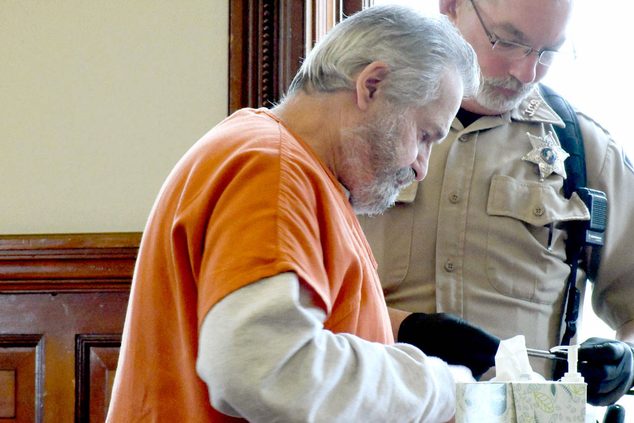 Michael Schluetz is fingerprinted with assistance from Jefferson County Sheriff’s Deputy Bill Wells after Schluetz was sentenced to more than seven years for communication with a minor for immoral purposes and attempted child rape. (Jeannie McMacken/Peninsula Daily News)