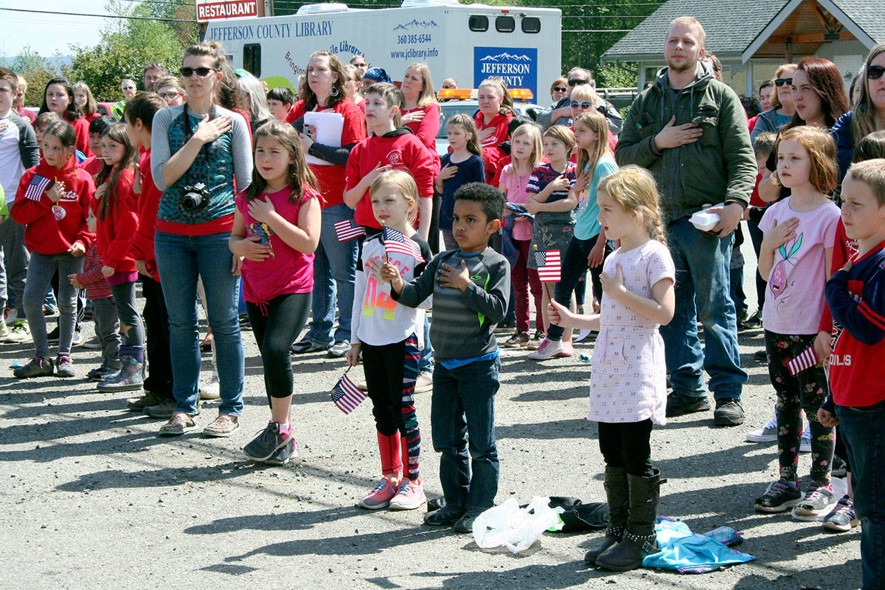 Students and parents from both Brinnon and Quilcene schools stand during the Pledge of Allegiance on Friday following the Loyalty Day Parade. (Brian McLean/Peninsula Daily News)