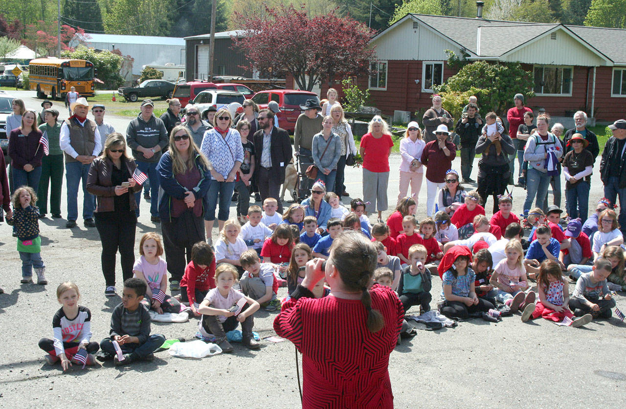 Students from Quilcene Elementary and other members of the crowd, including Jefferson County elected officials, listen to music from Kendra and Jim following the Loyalty Day Parade on Friday in Brinnon. (Brian McLean/Peninsula Daily News)