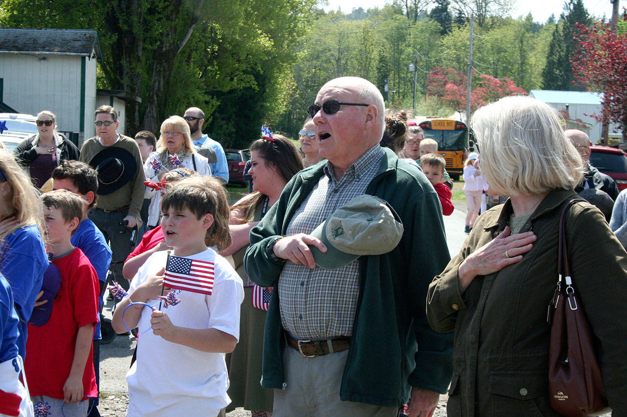 Members of the Loyalty Day crowd sing along to “God Bless America” during the program that followed the parade on Friday in Brinnon. (Brian McLean/Peninsula Daily News)