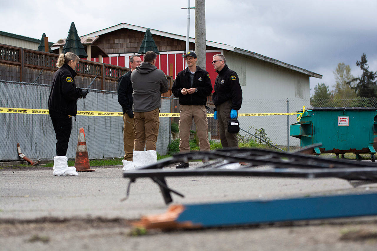FREDS Guns owner Seth Larson talks to Clallam County Sheriff’s detectives April 14 after someone drove a forklift through his store and sole about two dozen handguns. (Jesse Major/Peninsula Daily News)