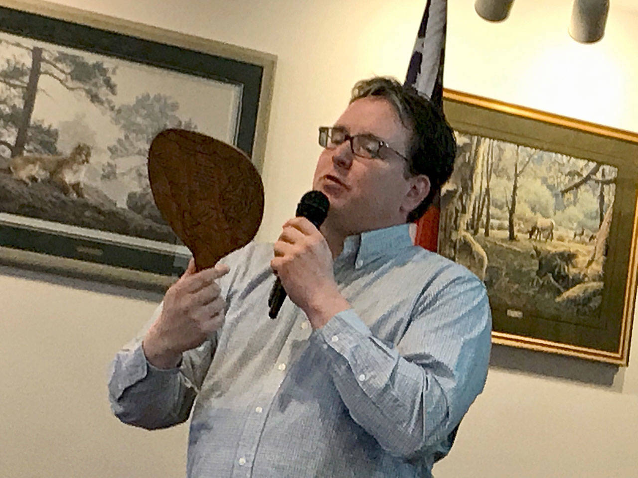 At a presentation Tuesday, Black Ball Ferry Line co-owner Ryan Malane reads from a decades-old hand-held fan that promoted the Olympic Loop scenic route in 1931, when the company ran ferry service now operated by Washington State Ferries. (Paul Gottlieb/Peninsula Daily News)