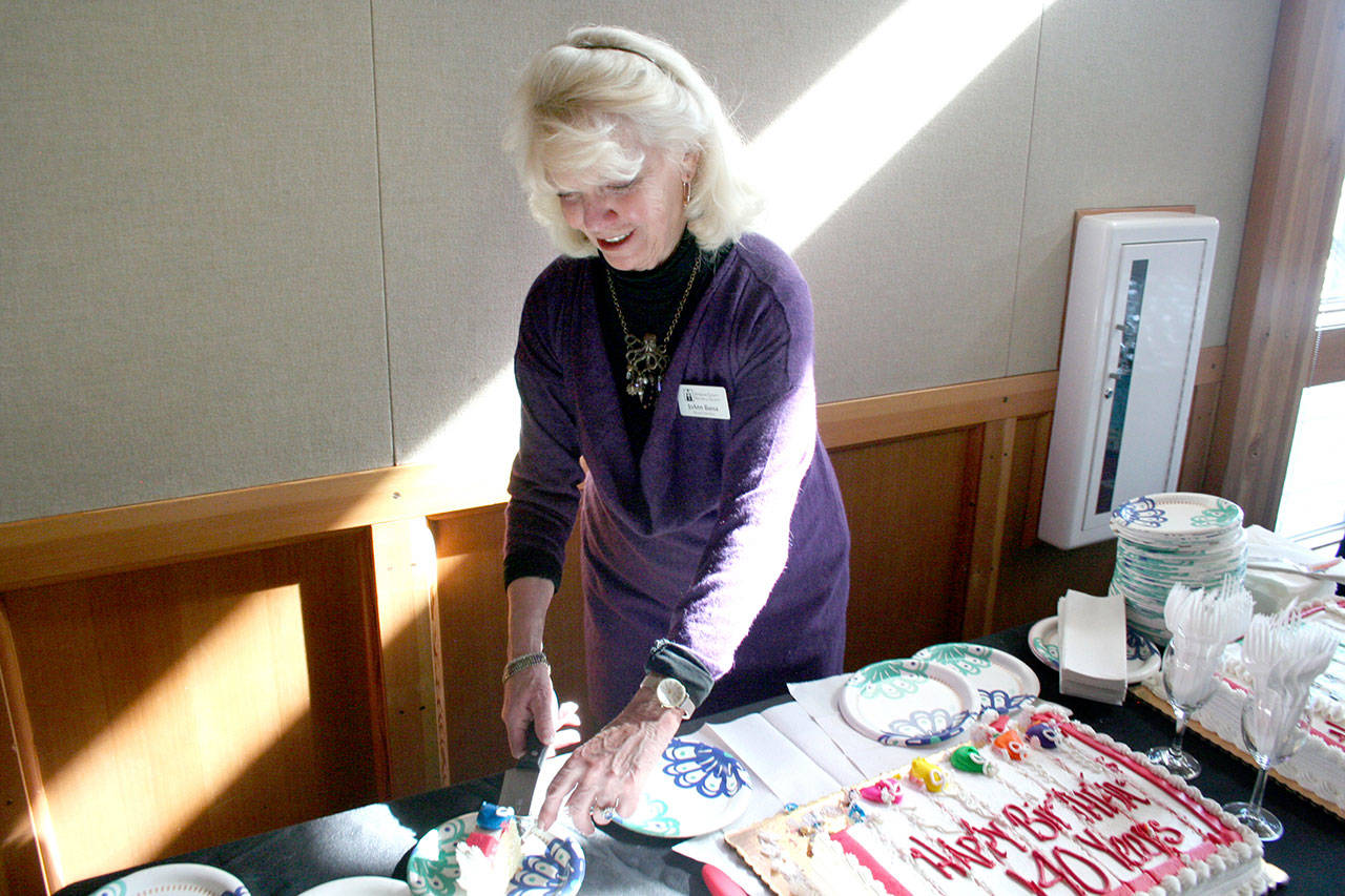 JoAnn Bussa, who has been on the board for the Jefferson County Historical Society for 20 years, cuts the birthday cake Friday at the Northwest Maritime Center during a ceremony to celebrate the society’s 140th anniversary. (Brian McLean/Peninsula Daily News)