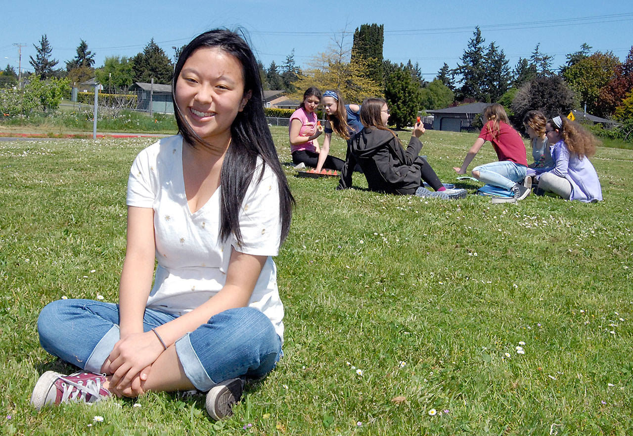 Sarah Lee takes a moment to enjoy the sunshine at Blue Heron Middle School. (Keith Thorpe/Peninsula Daily News)