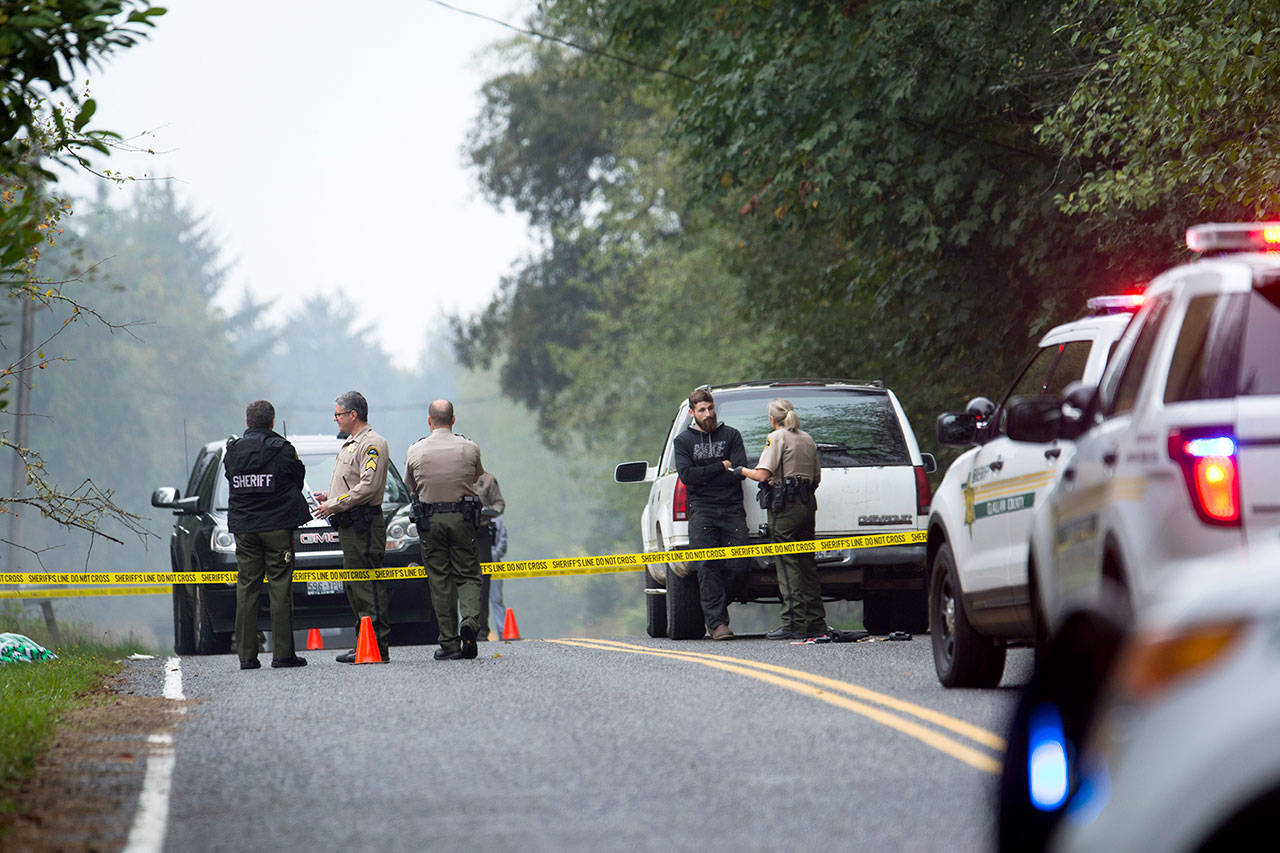 Investigators are shown at the scene of a shooting on Whiskey Creek Beach Road west of Joyce on Oct. 8 in this file photo. Garry Edwards and his wife, Melissa Edwards, have both been charged with misdemeanor assault. (Jesse Major/Peninsula Daily News)