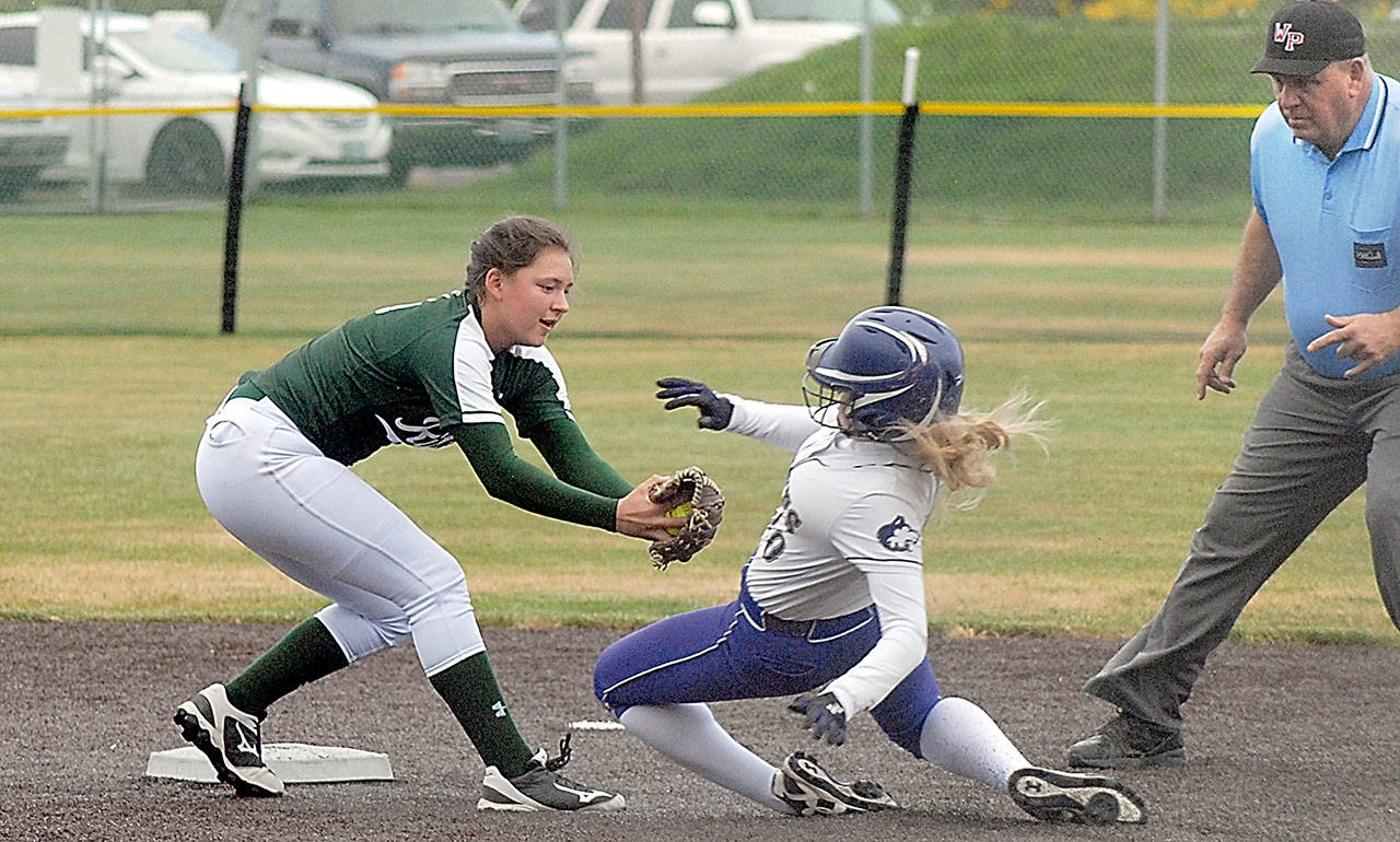 Keith Thorpe/Peninsula Daily News Sequim’s Greta Christiansen, center, attempts to reach second as Port Angeles’ Jada Cargo waits to make the tag while umpire Scott Ramsey looks on in the second inning of Tuesday’s playoff game at Billy Whiteshoes Memorial Park west of Port Angeles.