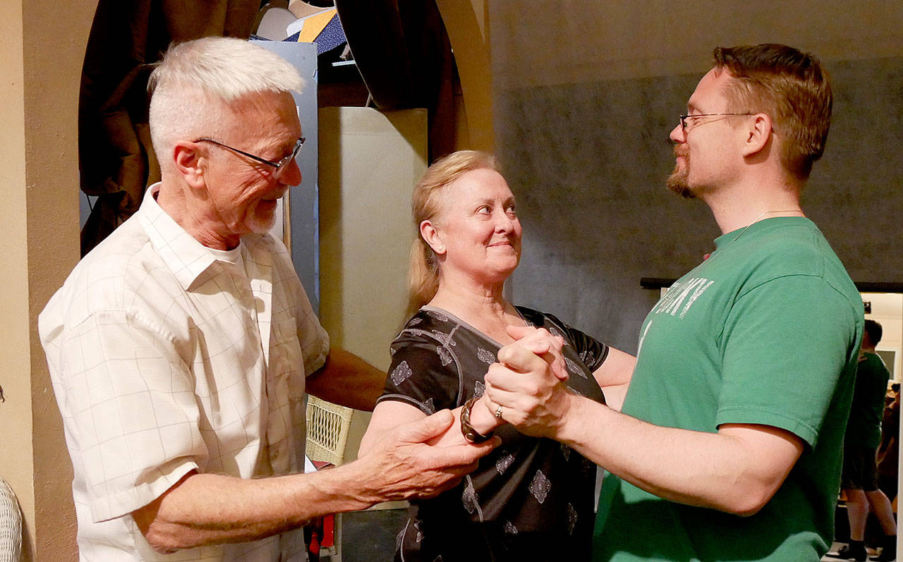 Director Greg Scherer, left, uses his classical dance background to coach Cheryl DiPietro and Michael Sickles in a waltz. (Olympic Theatre Arts)