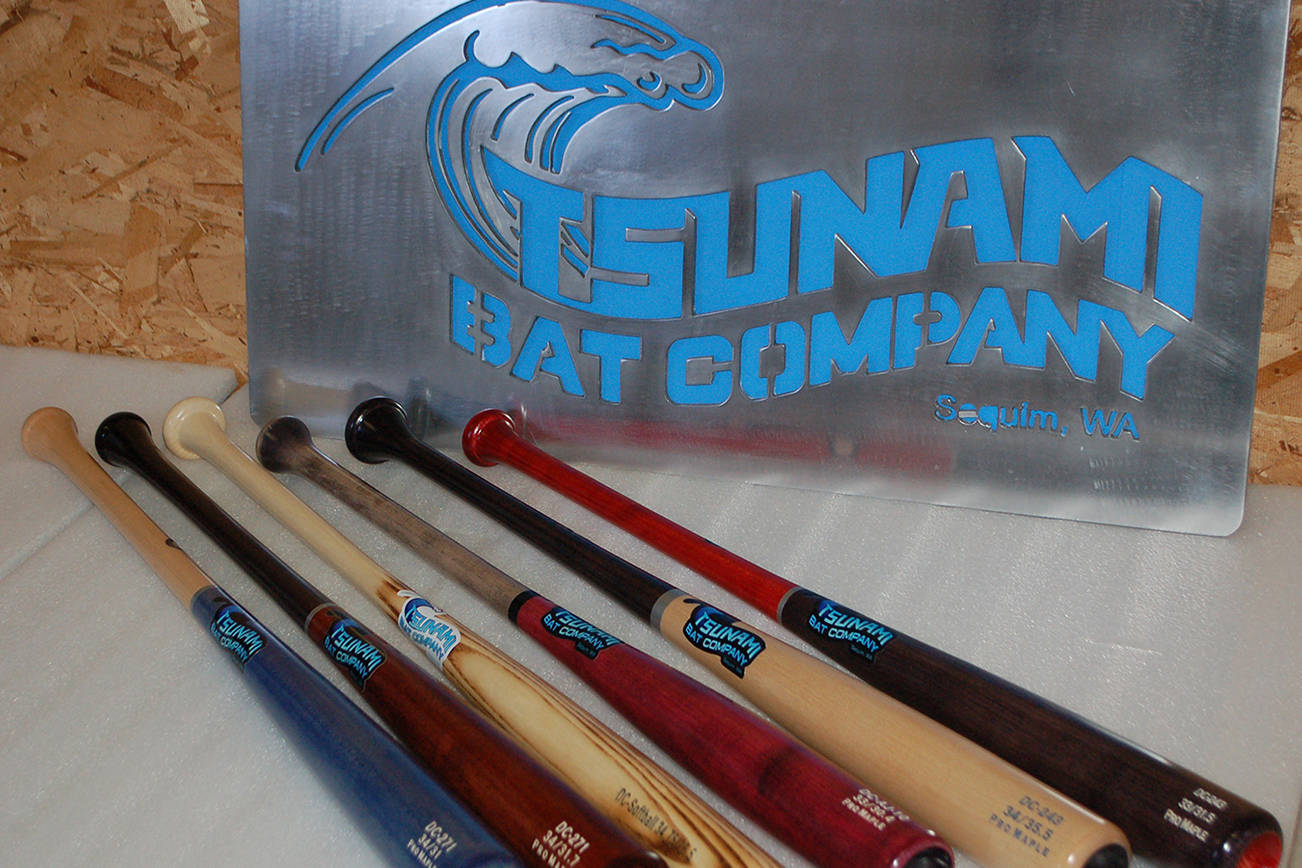 Several finished Tsunami Bat Company bats on display with the Sequim company’s sign. Conor Dowley/Olympic Peninsula News Group.