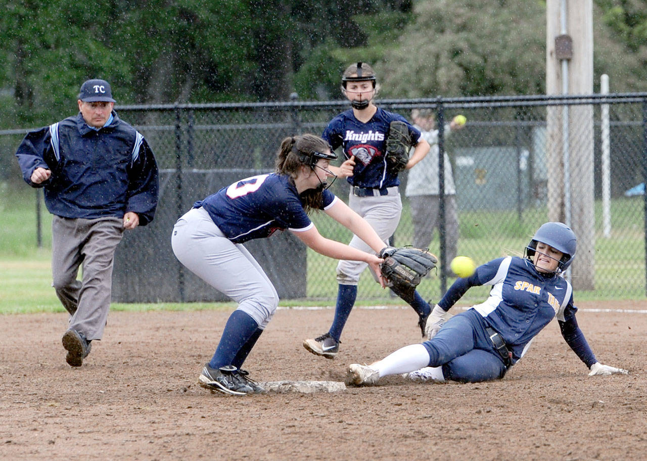 Lonnie Archibald/for Peninsula Daily News Forks’ Julia Lausche slides safely into second base while King’s Way Christian’s Tyra Schroeder awaits the throw.