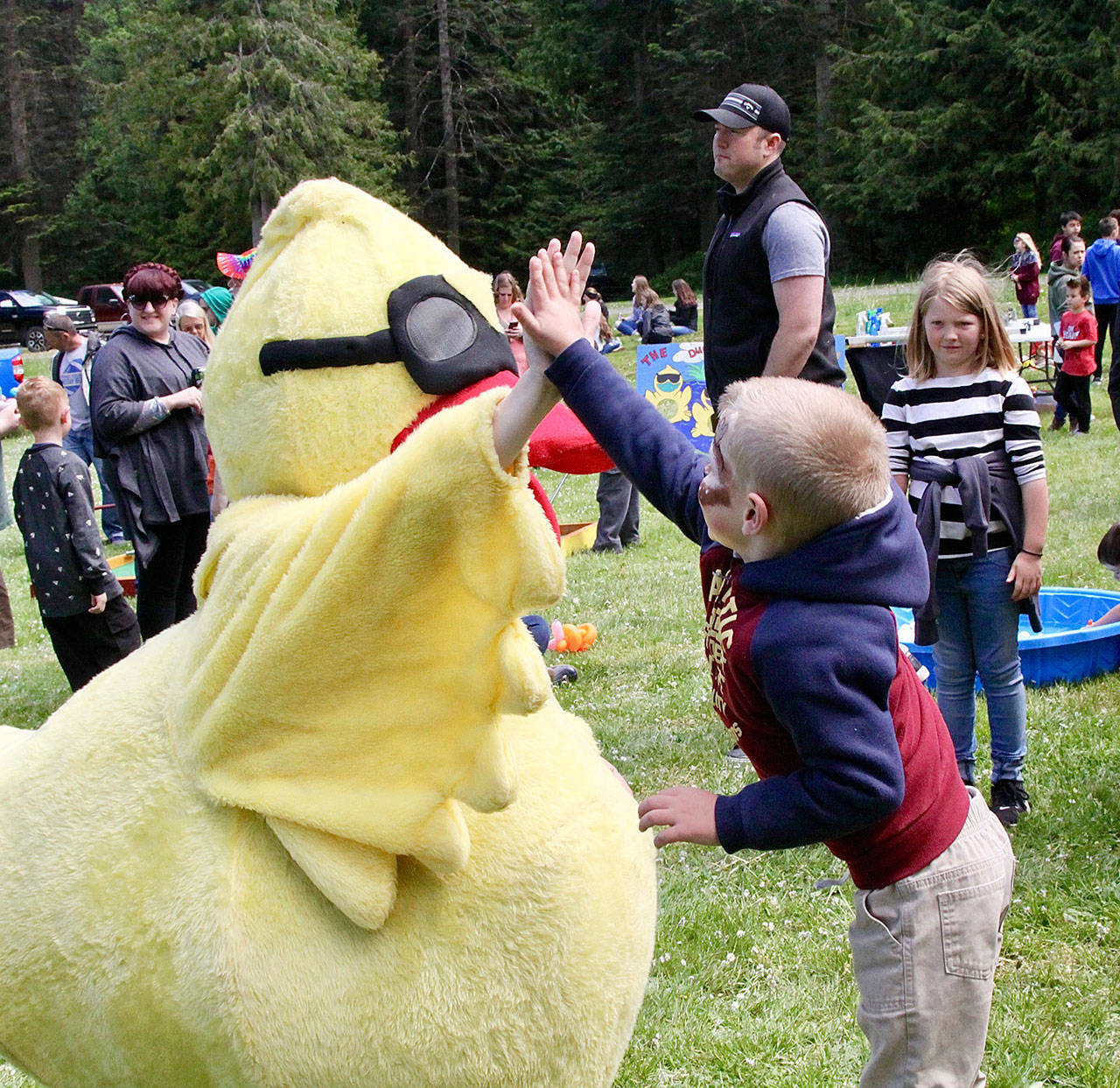 Isaiah Young, age 6, gets a high five from the Duck Derby mascot Sunday. (Dave Logan/for Peninsula Daily News)