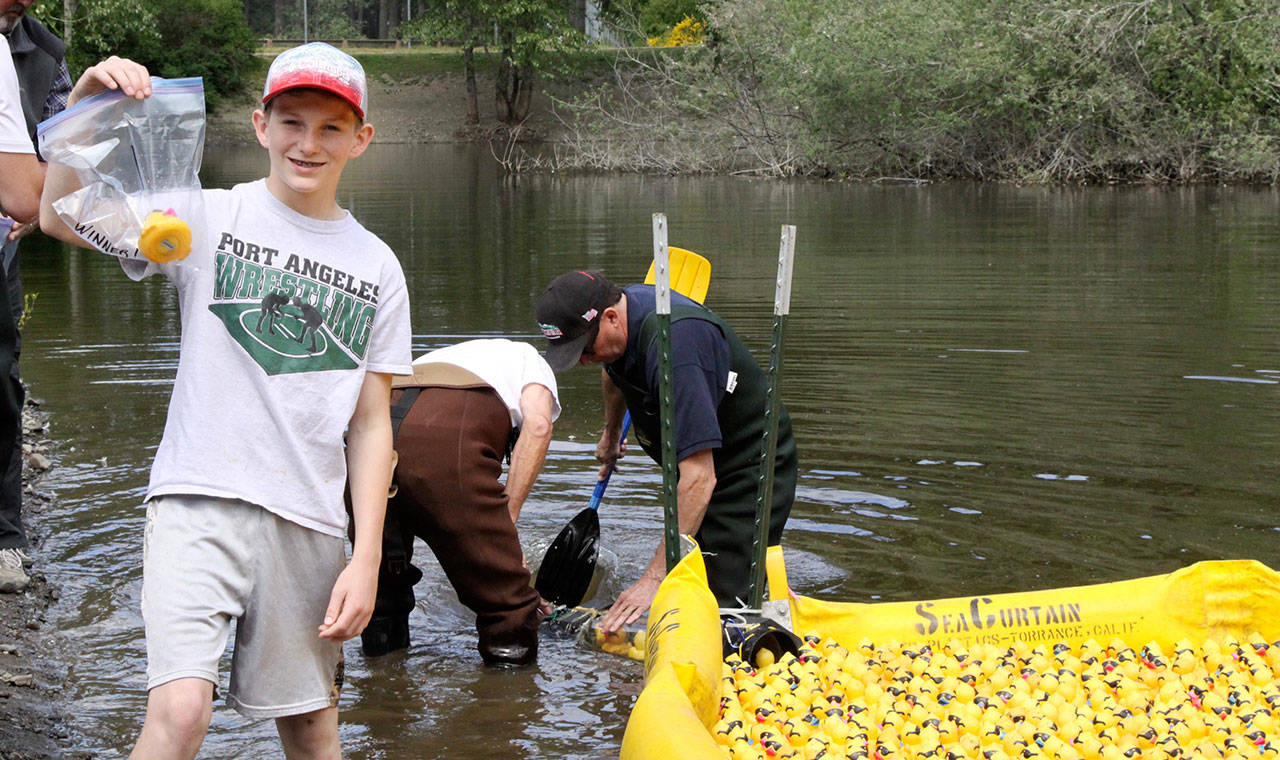 Ethan Abrams holds up the winning duck in Sunday’s Duck Derby at the Lincoln Park pond. (Dave Logan/for Peninsula Daily News)