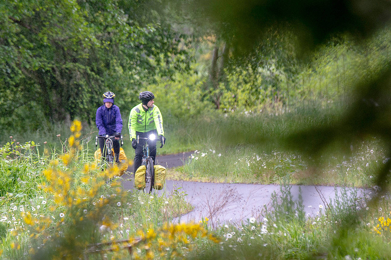 Jordon Lowe, left, and Justin Fritz, both of Victoria, B.C., cycle on the Olympic Discovery Trail along Discovery Bay on Monday. (Jesse Major/Peninsula daily News)