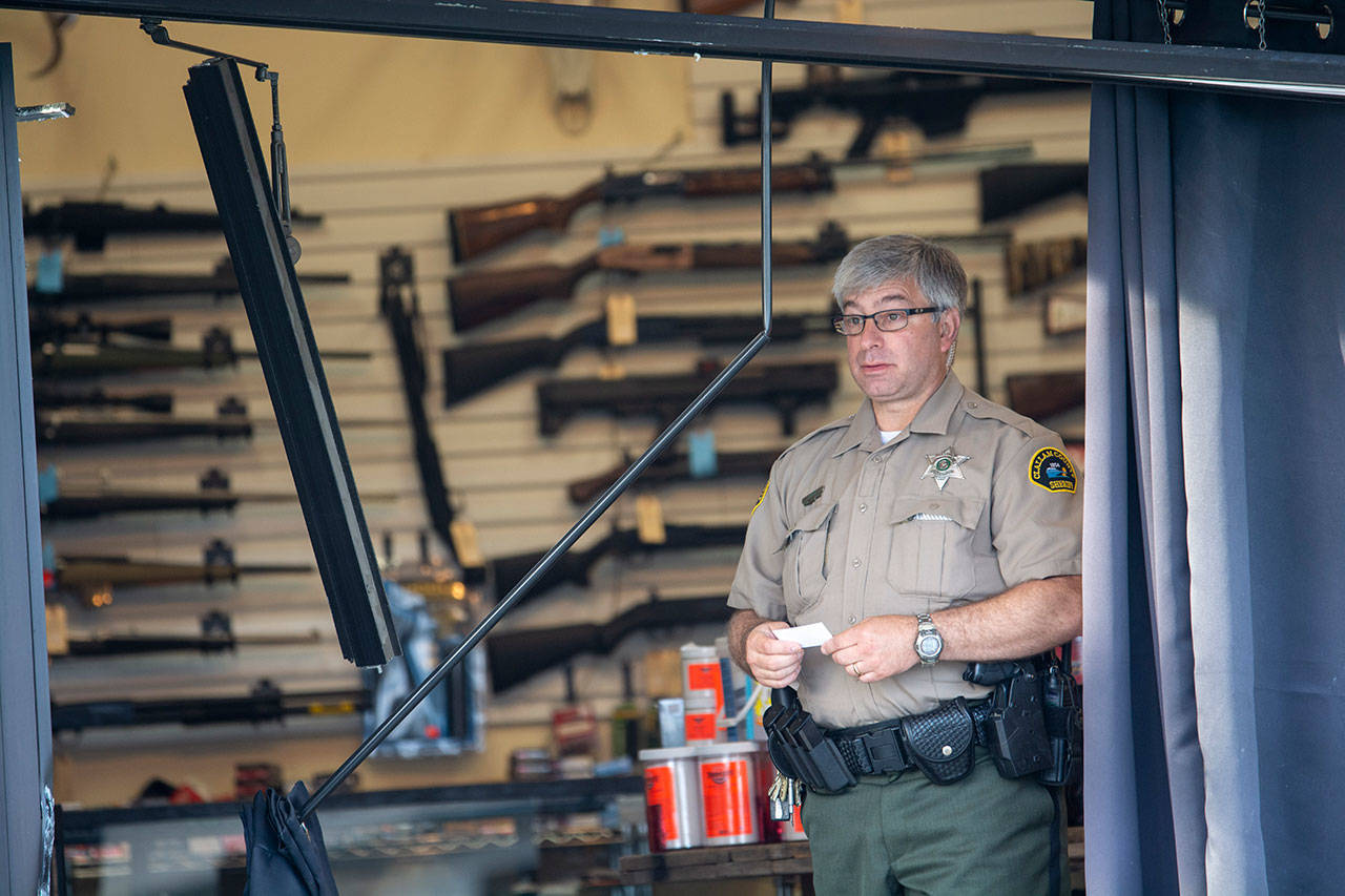 Clallam County Sheriff’s Deputy Bill Cortani stands in FREDS Guns near Sequim after someone used heavy equipment to break into the store in this file photo. (Jesse Major/Peninsula Daily News)