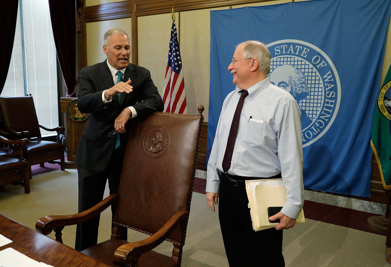 Gov. Jay Inslee, left, talks with House Speaker Frank Chopp, D-Seattle after Inslee signed the state operating budget Tuesday at the Capitol in Olympia. (Ted S. Warren/The Associated Press)