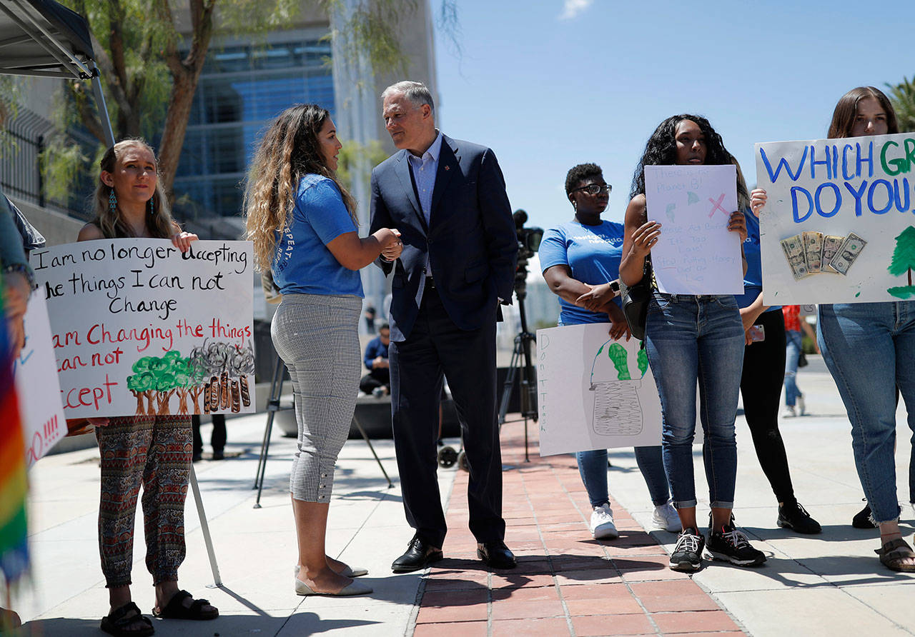 Democratic Presidential candidate Gov. Jay Inslee, center, meets with people at a climate change rally Friday in Las Vegas. (John Locher/The Associated Press)