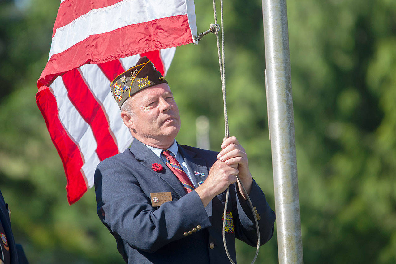 John Kent, commander of Veterans of Foreign Wars Post 1024, prepares to raise the American flag to half-staff at the start of the annual Memorial Day service at Mount Angeles Memorial Park in Port Angeles on Monday. (Jesse Major/Peninsula Daily News)