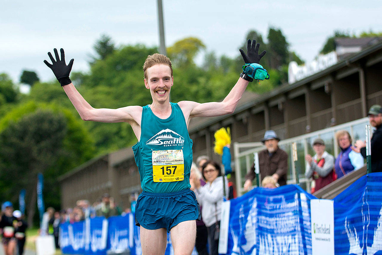 North Olympic Discovery Marathon winner Keith Laverty of Bainbridge Island celebrates as he crosses the finish line, breaking the previous record by more than one minute. (Jesse Major/Peninsula Daily News)