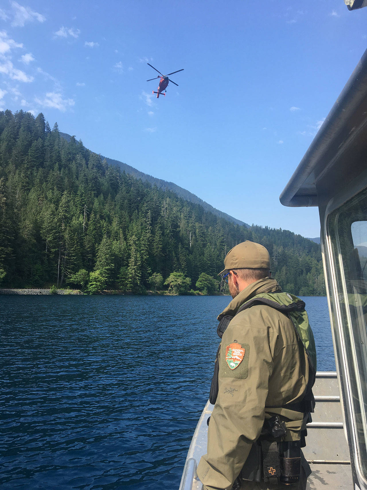 A U.S. Coast Guard helicopter aids Olympic National Park Rangers in searching for a missing woman at Lake Crescent on Tuesday. (National Park Service)