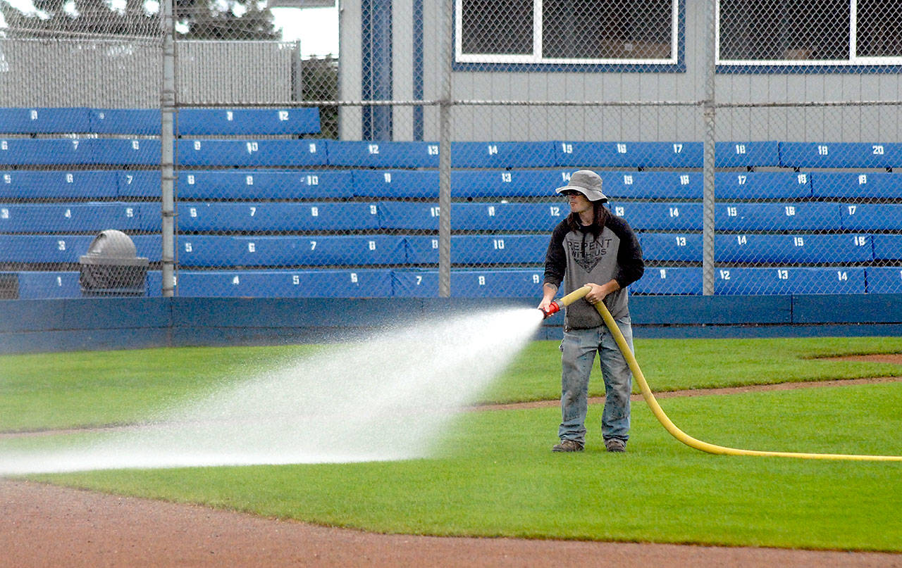 Eli Hammel of the Port Angeles Parks and Recreation Department hoses down the infield at Civic Field on Wednesday in preparation for this evening’s season opener of the Port Angeles Lefties baseball team. (Keith Thorpe/Peninsula Daily News)